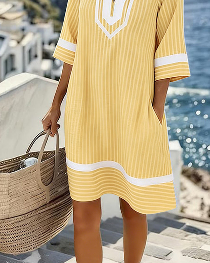 Mujer luciendo un vestido de rayas casual con cuello V y manga corta, ideal para el verano.