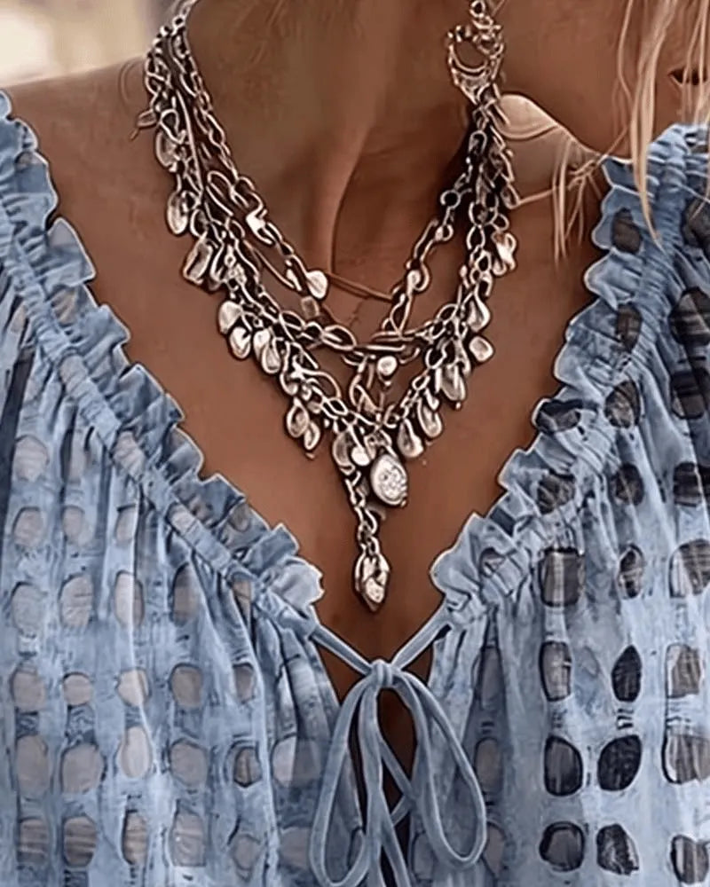 Frontal de blusa de lunares con escote V. Manga 3/4, estilo bohemio-chic, ideal para mujer.