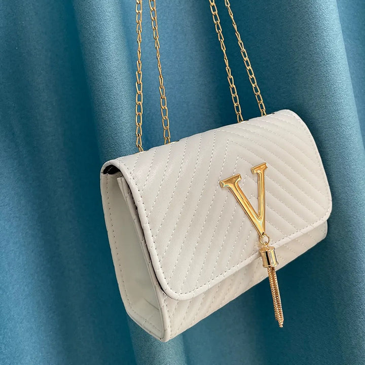 Elegante bolso de mano GLAMIRA para mujer con borla decorativa, disponible en negro, rosa y blanco.
