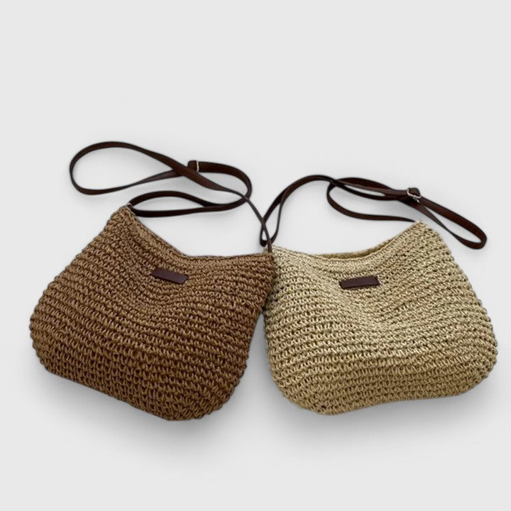 Bolso bandolera femenino de rafia trenzada en tono natural, accesorio bohemio y versátil.