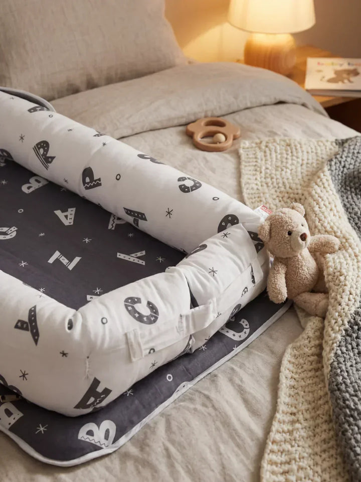 Nido portátil de algodón para el descanso del bebé, ideal para mantenerlo seguro en cuna.