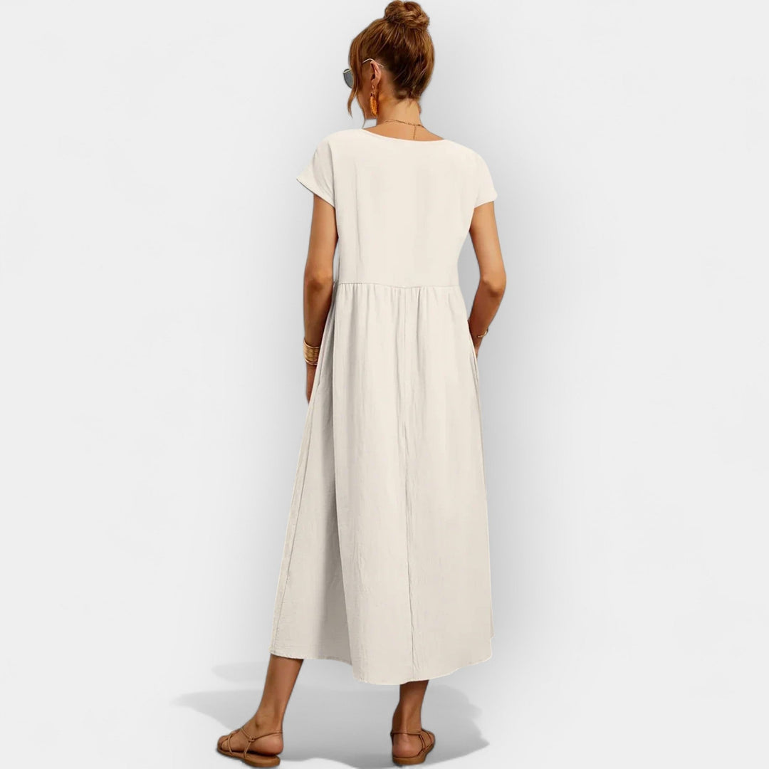 Mujer usando un vestido midi de algodón con bolsillos, estilo casual y muy cómodo.