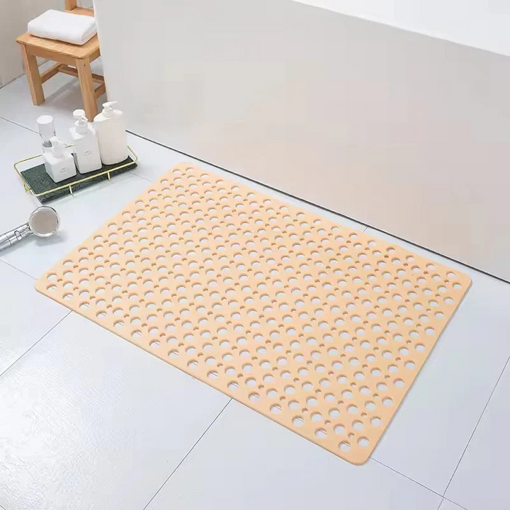 Alfombra de ducha antideslizante para confort, con superficie texturizada y orificios para drenaje rápido.