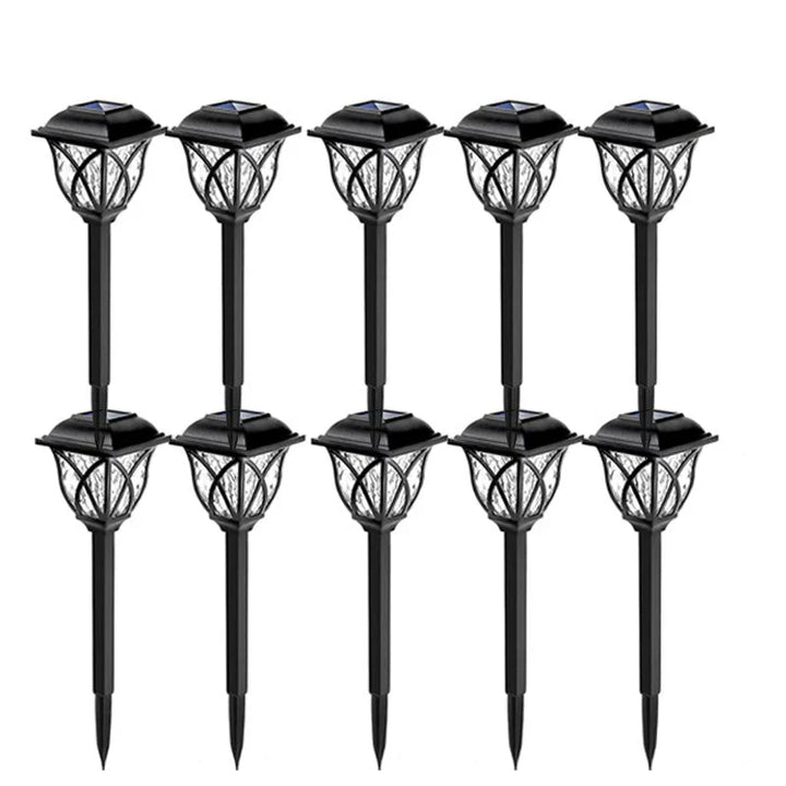 Lámpara solar LED de poste iluminando sendero, mejora el ambiente de tu jardín.