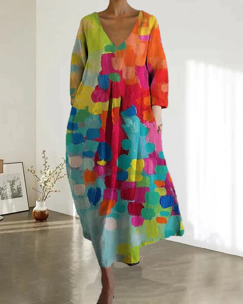Vestido largo de mujer con estampado floral artístico y escote en V. Diseño fluido y colorido para bodas, ceremonias y fiestas de verano.