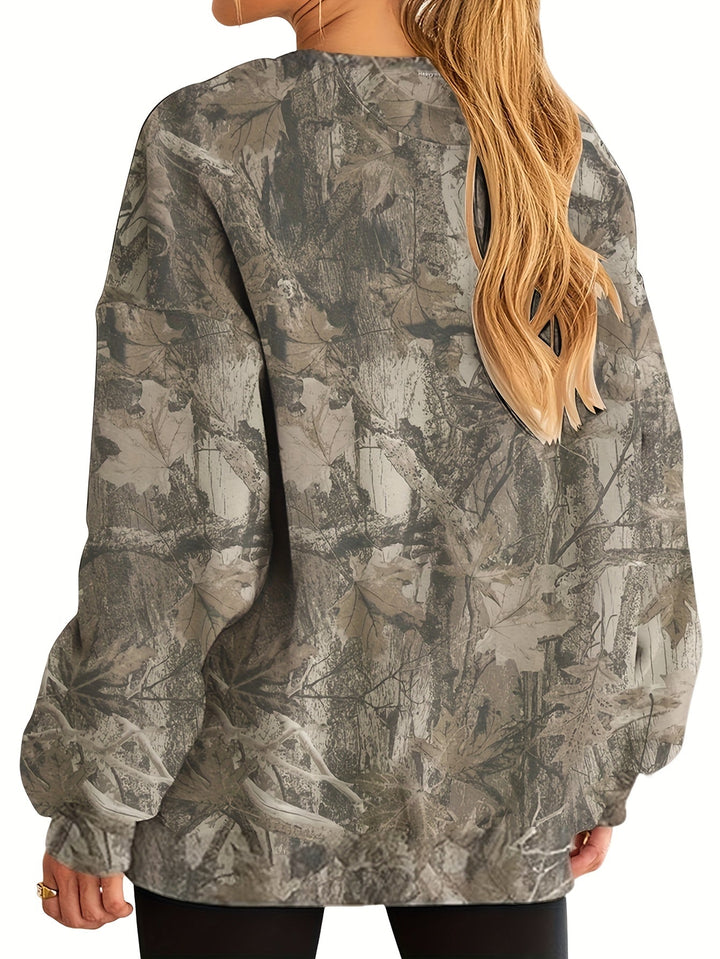 Mujer en entorno urbano con sudadera oversize camuflaje. Estilo casual chic y moda de calle.