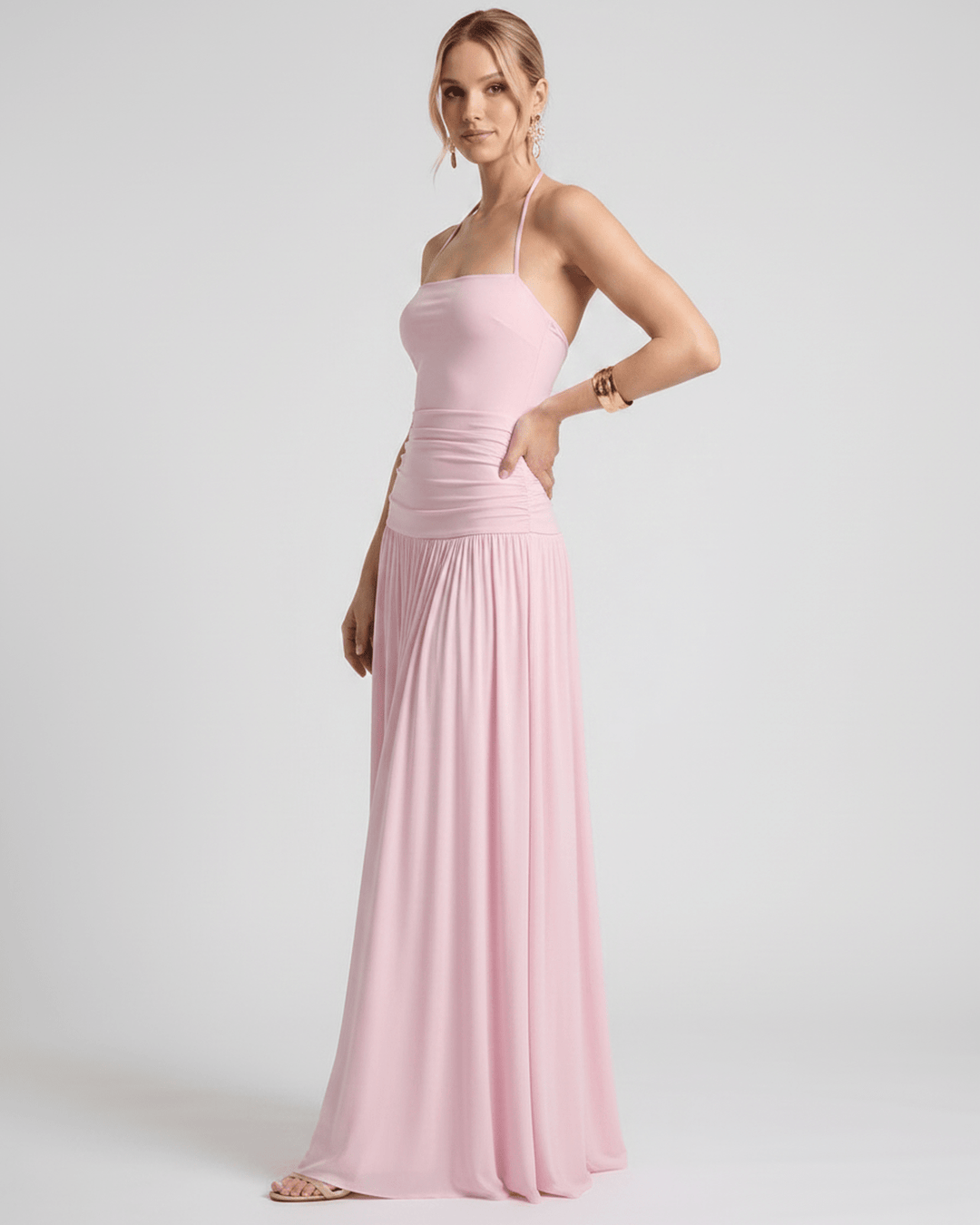 Mujer en un jardín con vestido maxi de verano. Cuello halter, fluido y moda femenina.