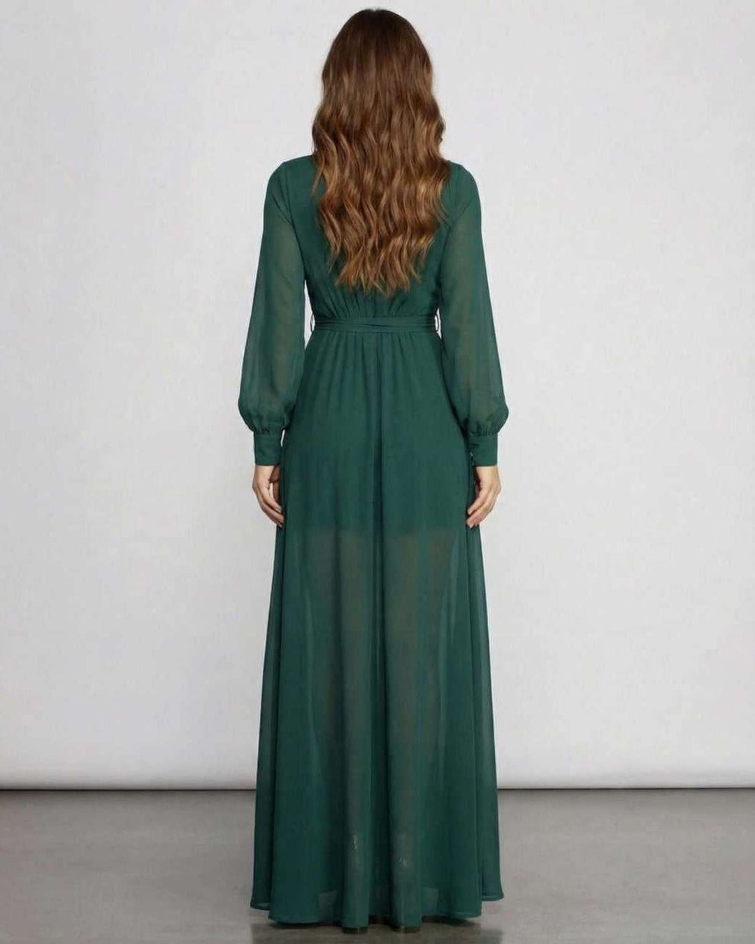 Vestido largo verde esmeralda para invitada de boda. Moda formal fluida con manga larga, perfecto para ocasión especial.
