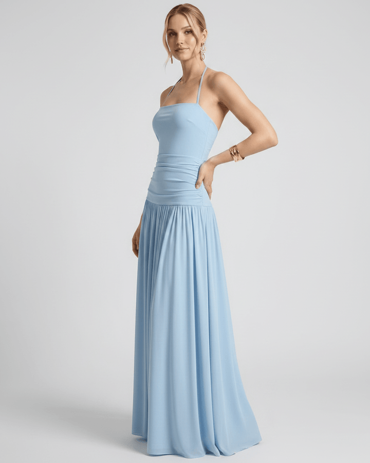 Modelo luciendo vestido maxi halter elegante y fluido. Moda femenina sin mangas para cualquier ocasión.