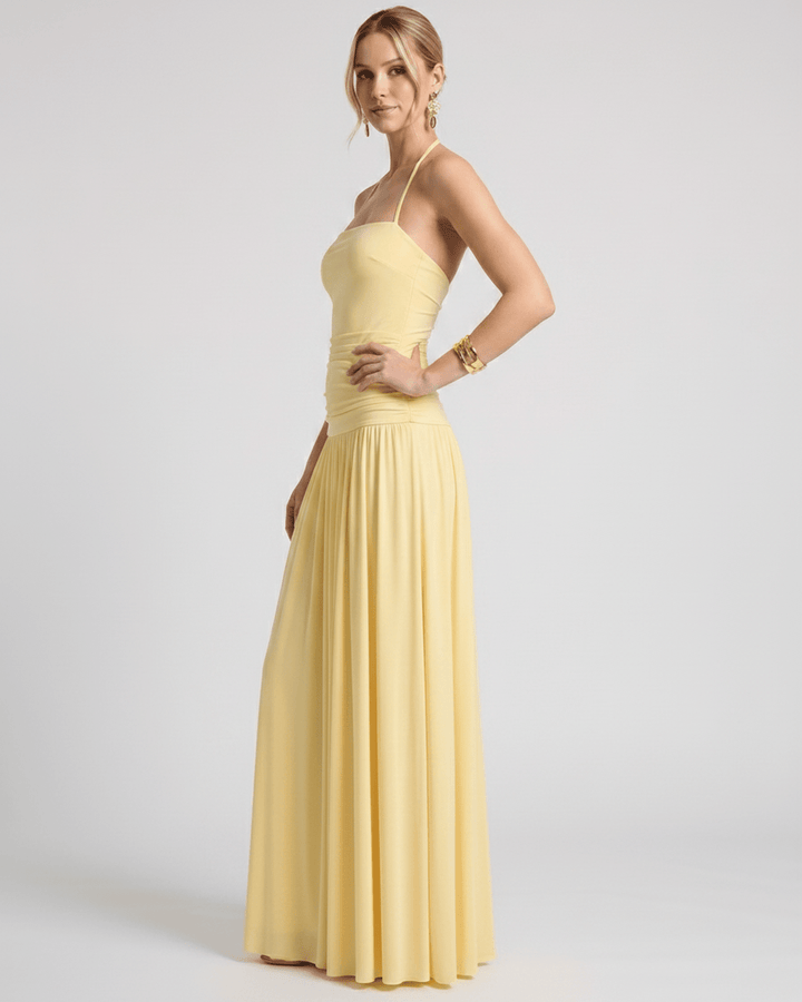 Perfil de mujer luciendo vestido maxi halter elegante. Caída fluida, ideal para eventos.