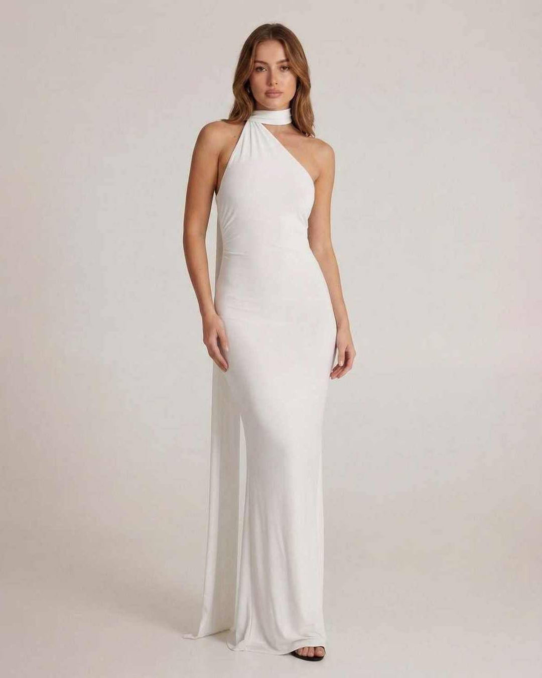 Vestido maxi blanco Elara con escote halter y espalda abierta. Elegante para ocasiones especiales y fiestas.