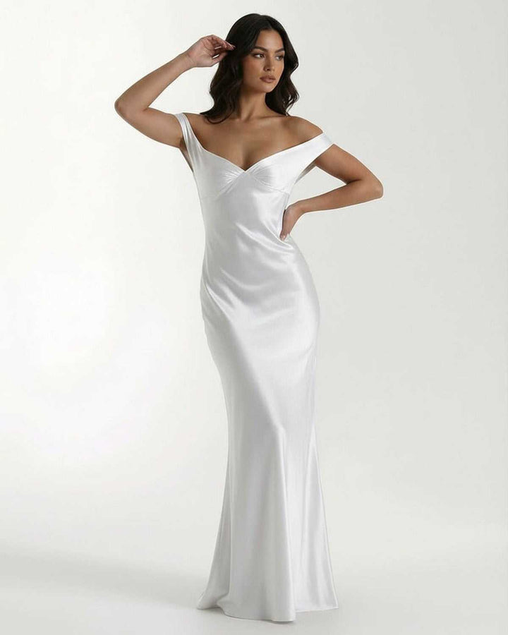 Mujer vistiendo vestido maxi blanco Elara off shoulder. Diseño elegante para noche, fiesta formal.