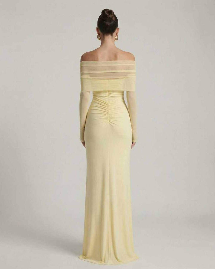 Vestido largo amarillo con mangas de malla transparentes, perfecto para bodas o graduaciones.