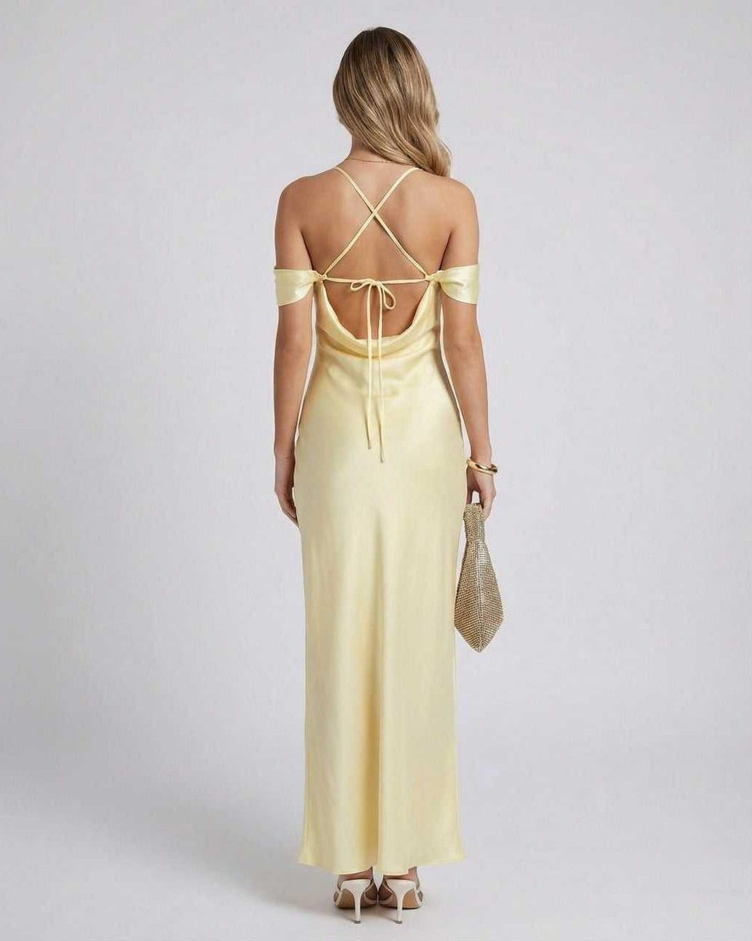 Mujer con vestido amarillo largo y fluido de hombros caídos, perfecto para eventos de noche o bodas elegantes.