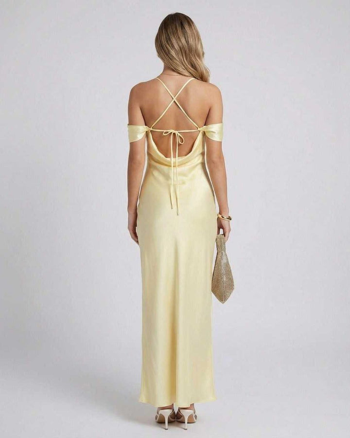 Mujer con vestido amarillo largo y fluido de hombros caídos, perfecto para eventos de noche o bodas elegantes.