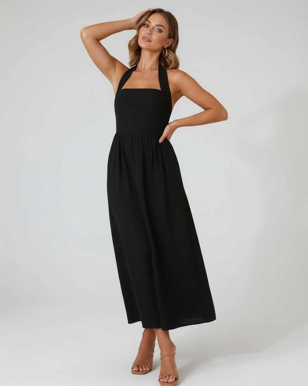 Elegante vestido midi negro halter para mujer, sofisticado y moderno, ideal para eventos o salidas casuales.