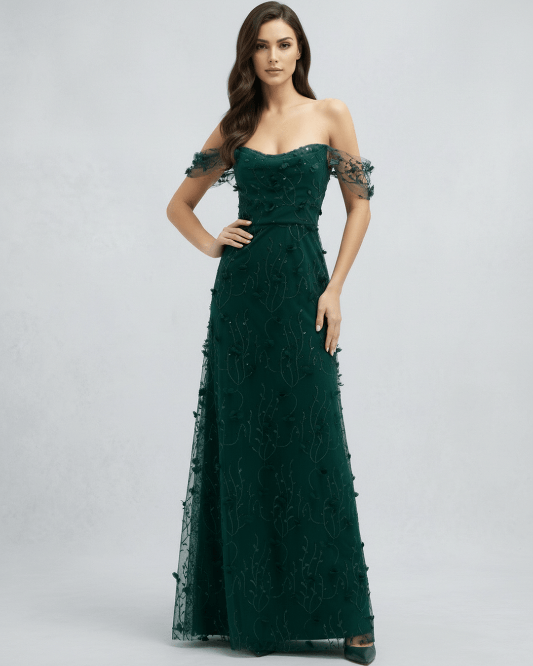 Mujer luciendo vestido maxi verde esmeralda, elegante y fluido, con mangas descubiertas, perfecto para bodas o cócteles.