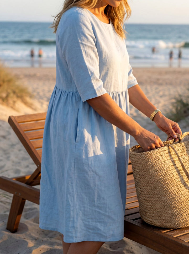 Vestido midi de lino azul con bolsillos y cintura fruncida para mujer. Cuello redondo, manga media. Estilo casual de verano.