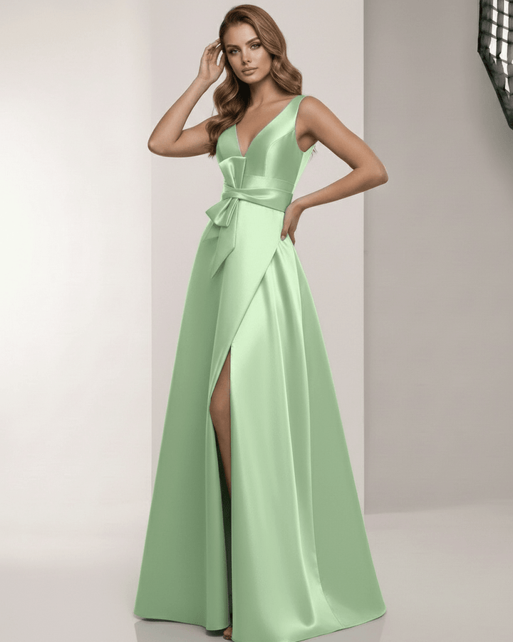 Vestido de mujer blanco, corte A y escote V profundo. Maxi, sin mangas, con lazo en cintura. Look sofisticado.