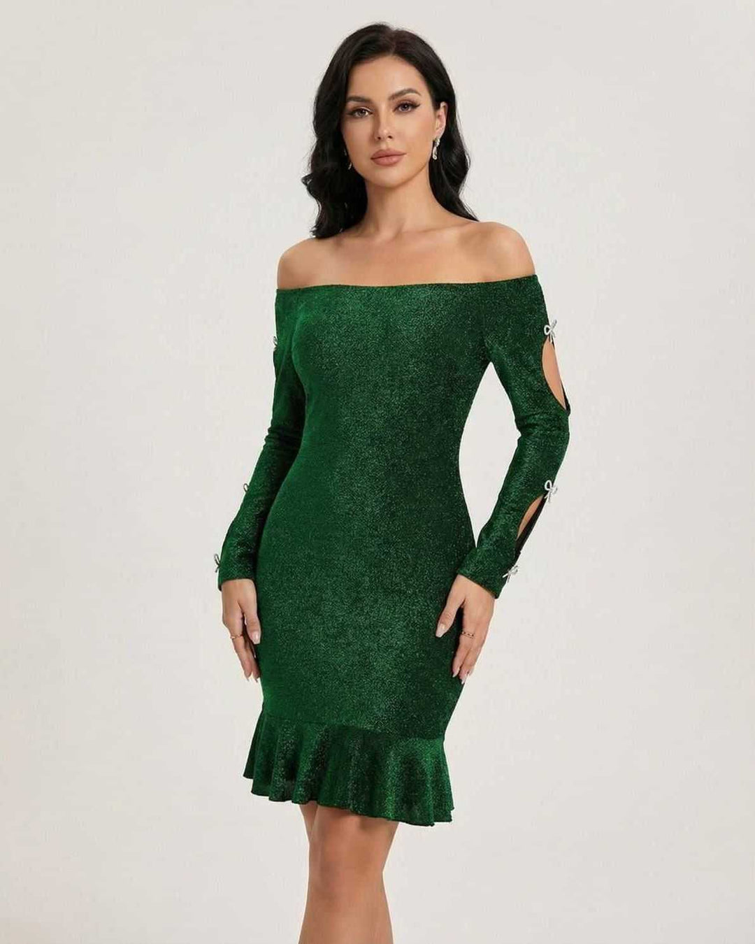 Modelo de mujer luciendo un vestido mini esmeralda elegante, con hombros descubiertos, ideal para fiesta.