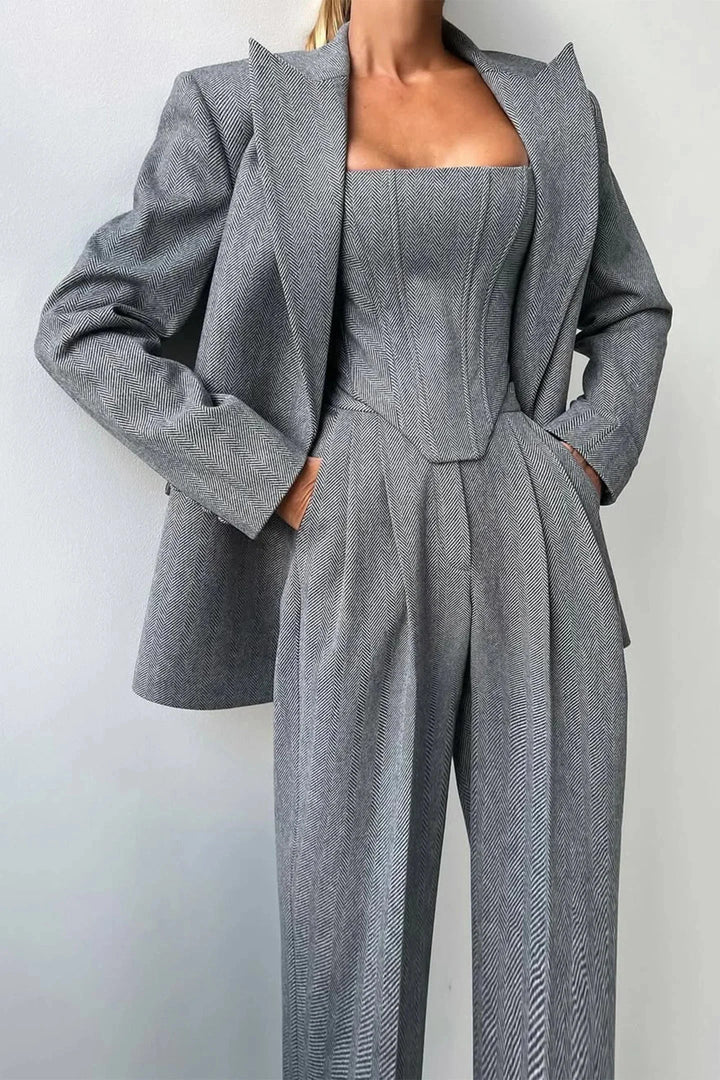 Conjunto elegante mujer tres piezas entallado gris. Top ajustado, estilo sofisticado y moda actual.