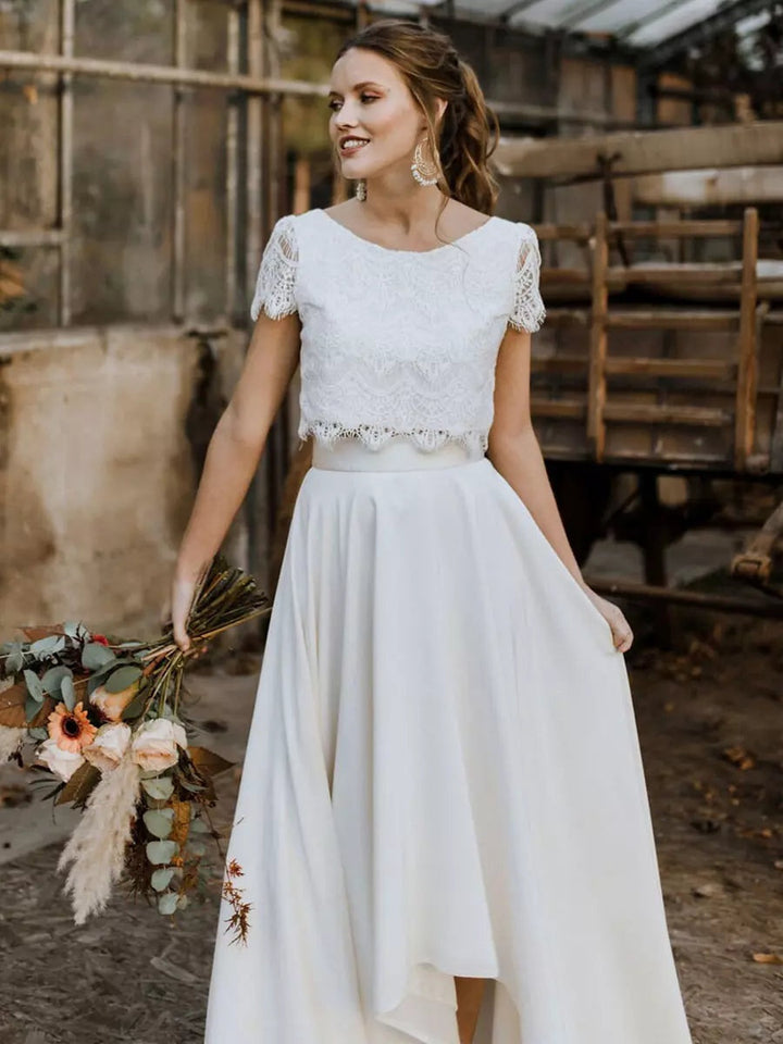 Elegante vestido de novia de dos piezas. Top de encaje y falda asimétrica. Moderno, ideal para ceremonia nupcial.