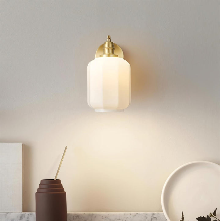 Lámpara de pared de latón pulido y vidrio. Diseño enchufable para fácil instalación y decoración.