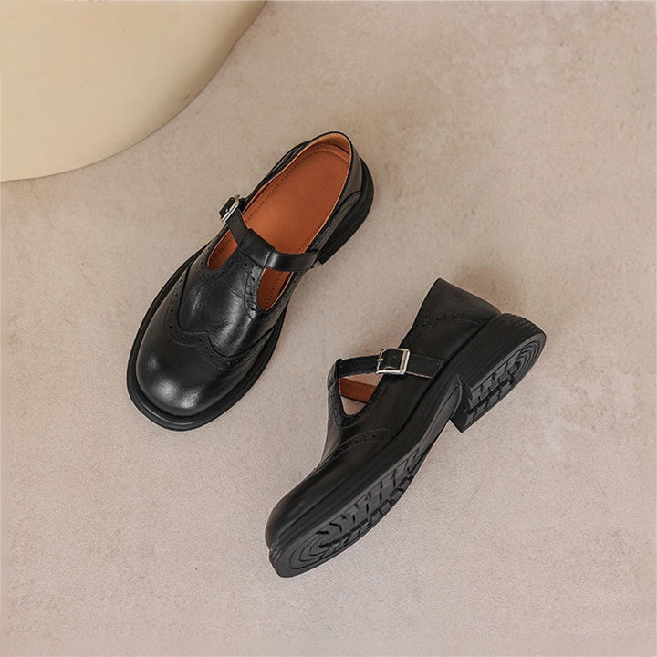 Detalle de correa T-strap en zapatos de mujer, estilo retro con perforaciones.