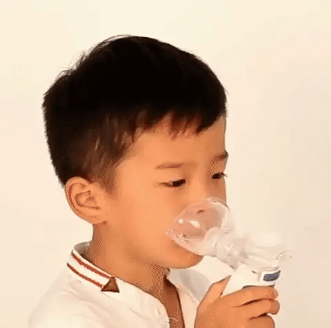 Niño utilizando nebulizador portátil ultrasónico para asma, brindando bienestar y salud respiratoria familiar.