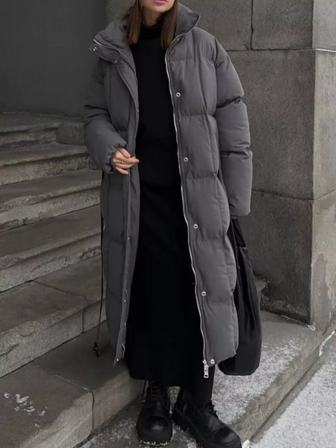 Chaqueta acolchada elegante para mujer, de corte largo, con cinturón que define la cintura.