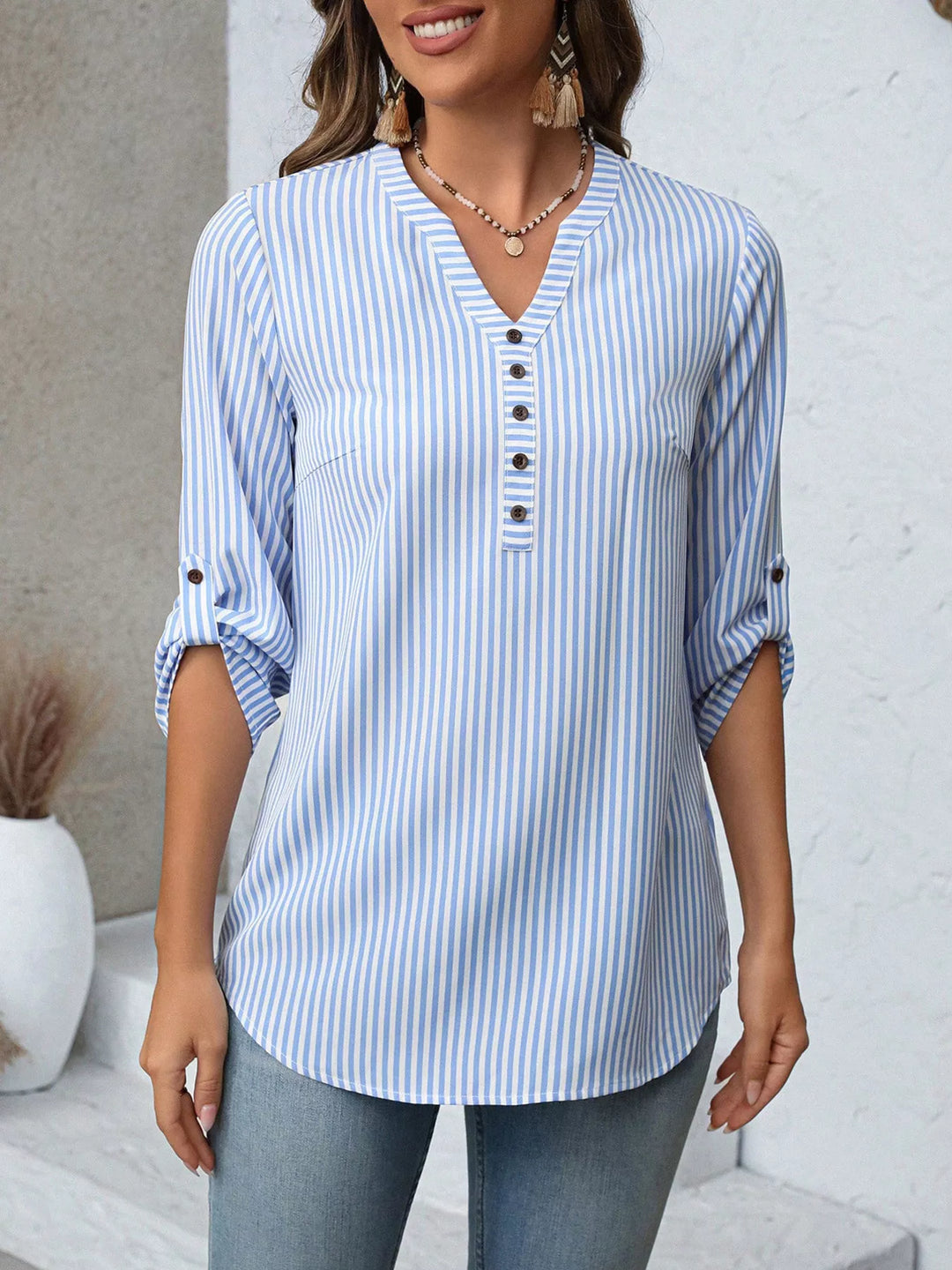 Elegante blusa de mujer con cuello en V, diseño a rayas, mangas ajustables para look casual.
