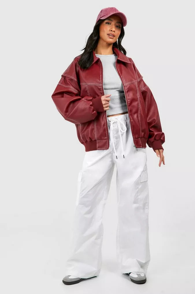 Detalle de costuras contraste en chaqueta bomber oversize de cuero sintético para mujer, estilo moderno.