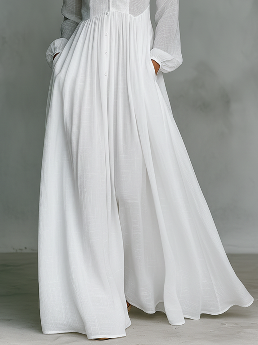 Mujer luciendo vestido maxi blanco minimalista y elegante. Prenda fluida de cuello alto para un look casual de verano.