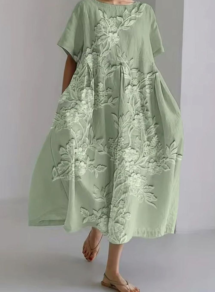 Vestido largo de mujer con apliques florales sutiles y cuello redondo clásico. Ideal para un look fresco de verano.
