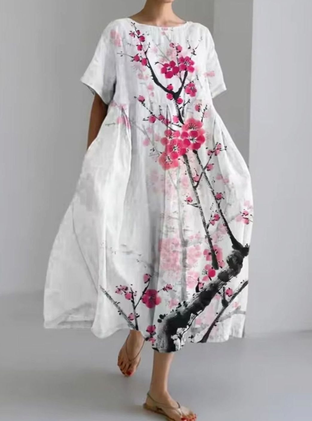 Hermoso vestido largo de mujer con intrincados apliques florales. Cuello redondo, silueta fluida para un look veraniego.