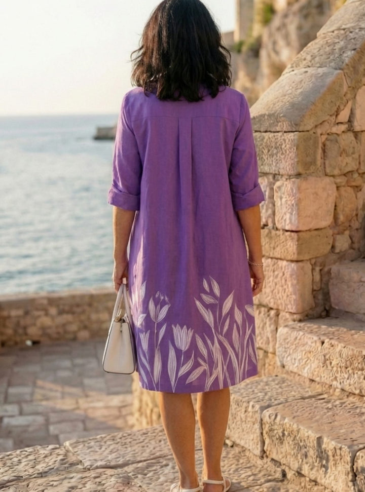 Primer plano de vestido camisero morado con estampado botánico. Estilo relajado y confortable para mujer en verano.