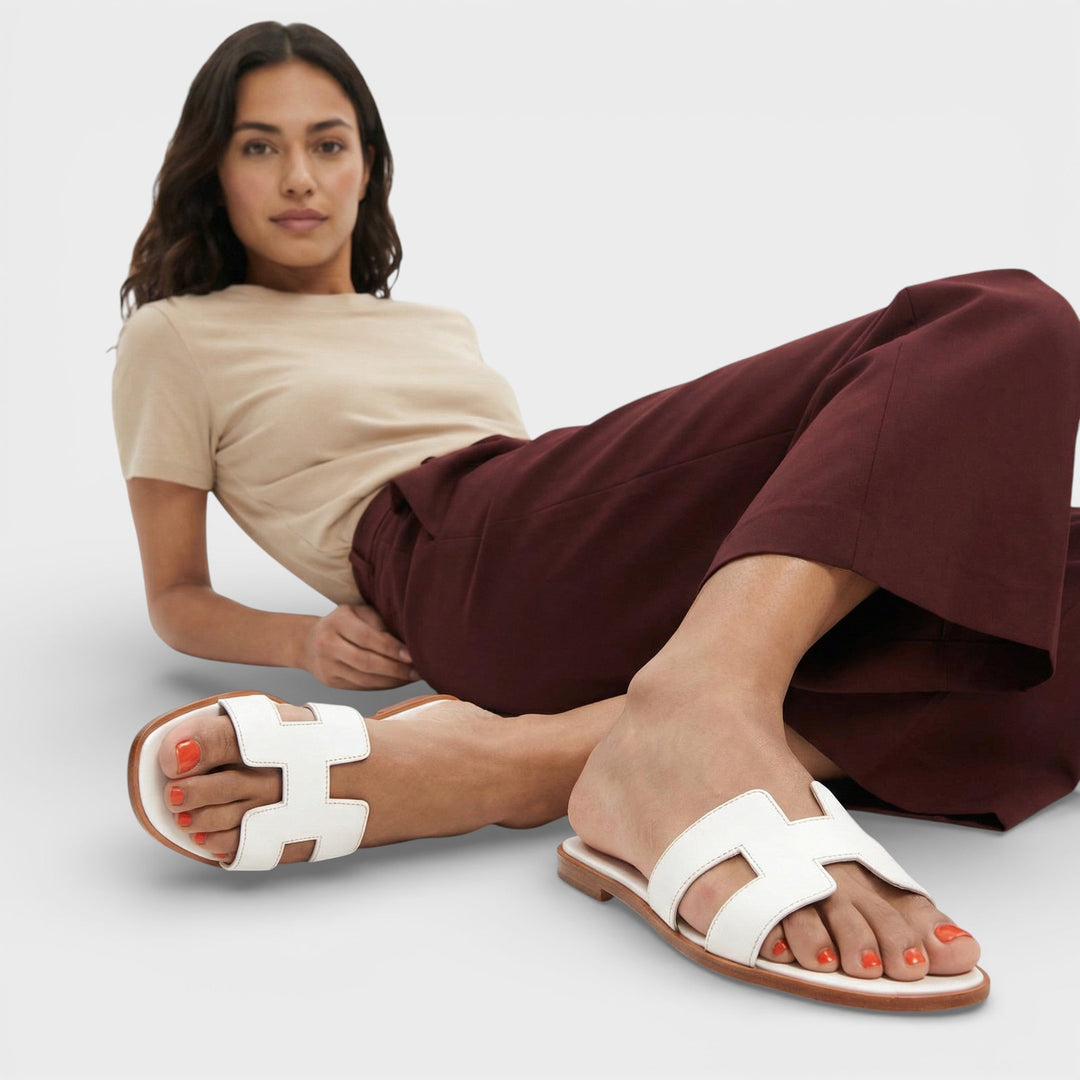 Primer plano de sandalias planas ELENA, estilo H. Confort supremo y diseño casual-elegante para mujer en verano.