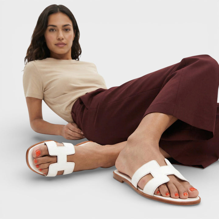 Primer plano de sandalias planas ELENA, estilo H. Confort supremo y diseño casual-elegante para mujer en verano.