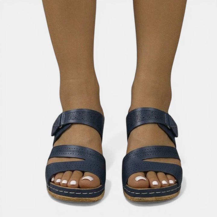 Vista lateral de sandalias de cuña ortopédicas para mujer. Diseño ergonómico y elegante para calzado de verano.