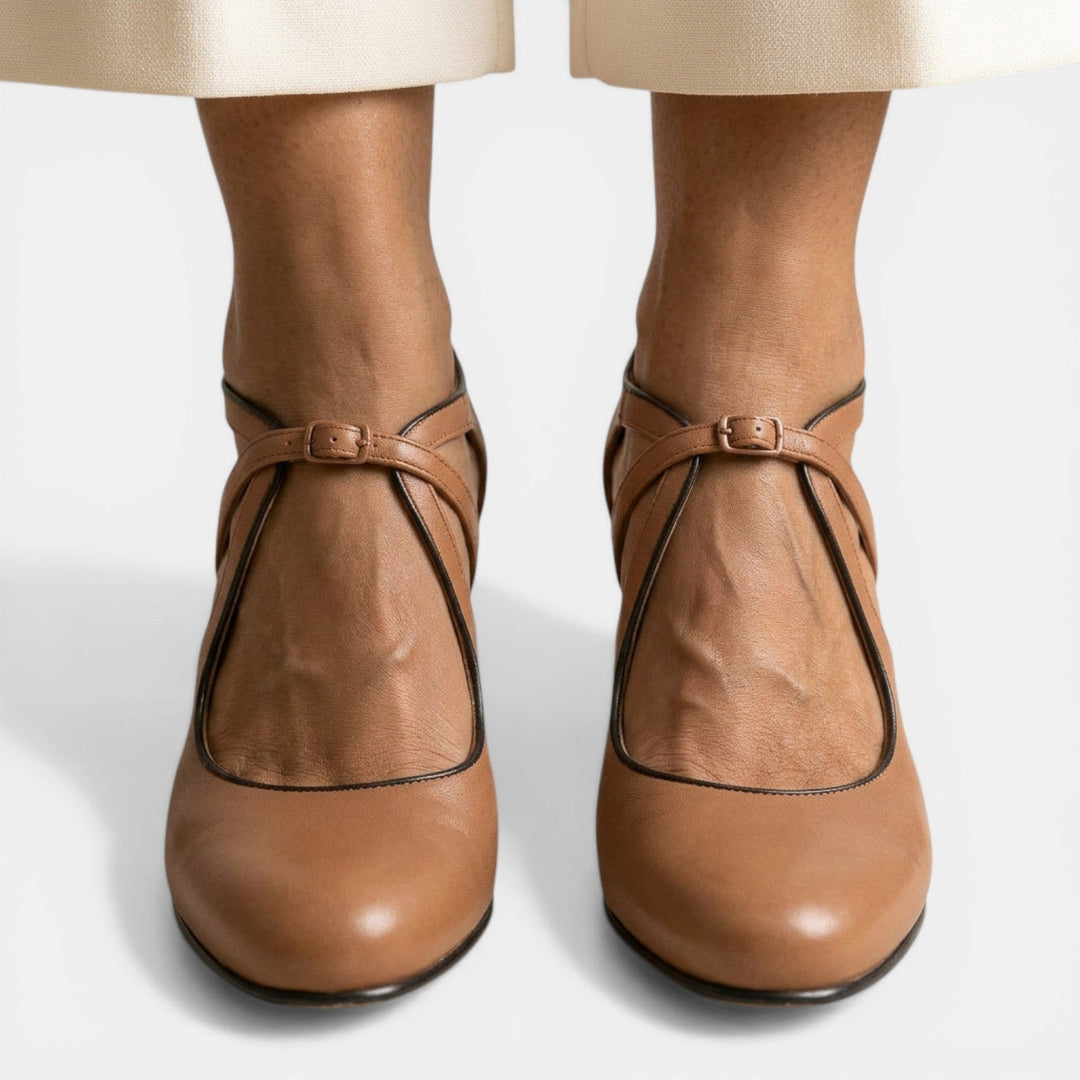 Detalle de sandalias T-strap para mujer, diseño clásico y cierre de hebilla, ideal para fiestas.