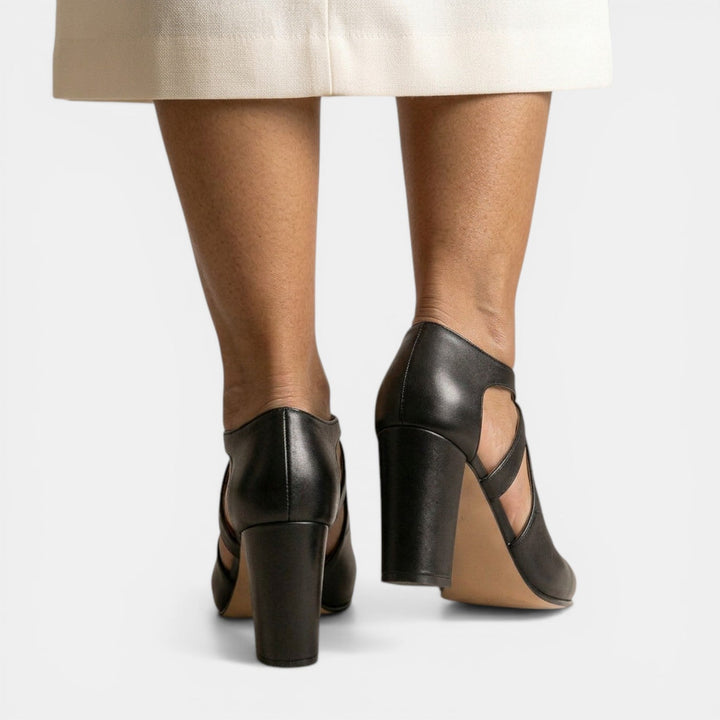 Primer plano de sandalias T-strap, resaltando su calidad y el cómodo tacón ancho para mujer.