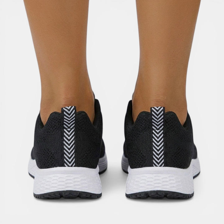 Mujer activa caminando con zapatillas ortopédicas, experimentando ligereza y soporte en cada paso diario.