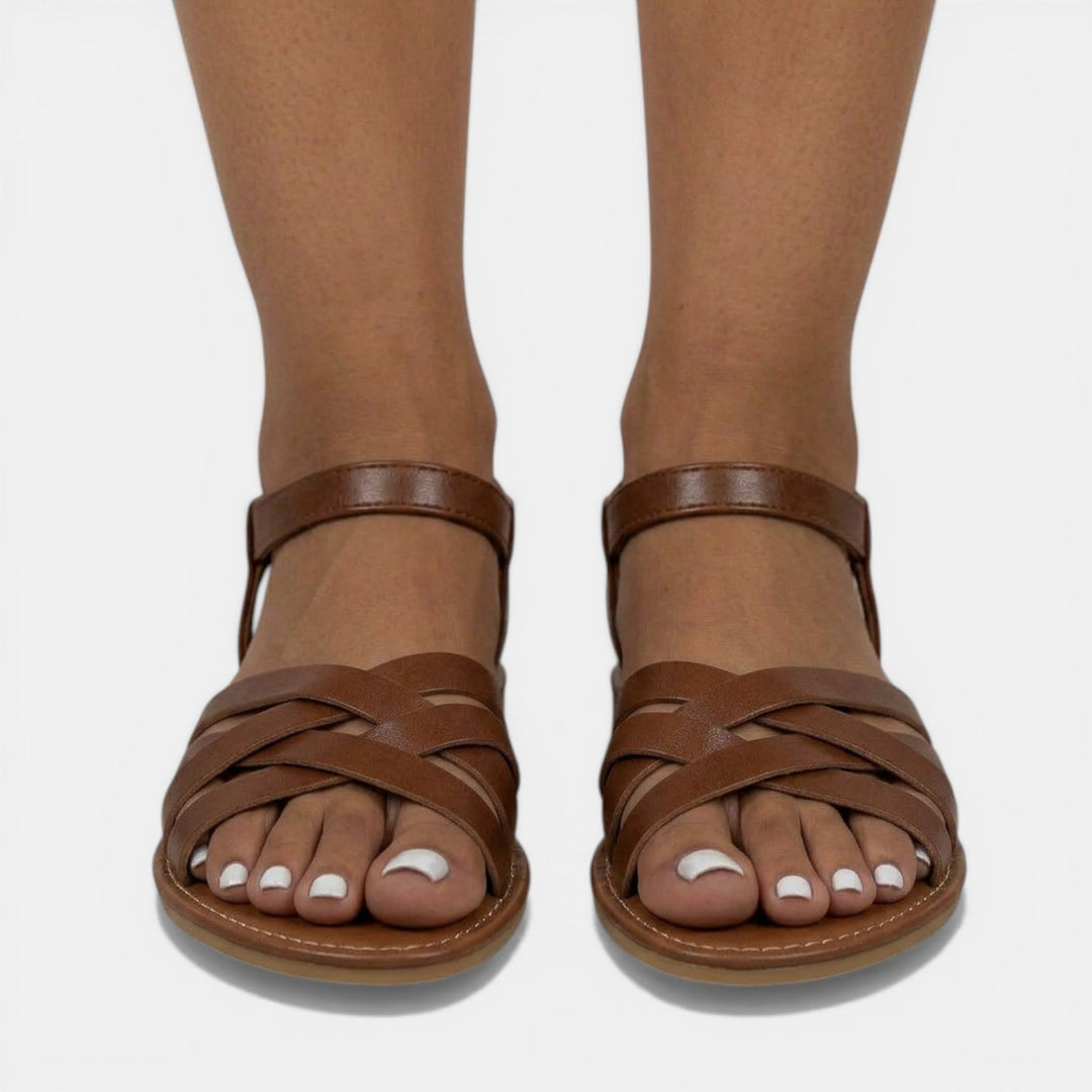 Vista superior de sandalias planas de mujer, con tirantes cruzados. Básicos de verano esenciales y moda femenina.