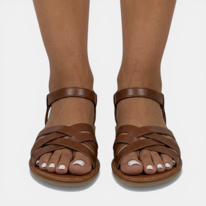 Vista superior de sandalias planas de mujer, con tirantes cruzados. Básicos de verano esenciales y moda femenina.