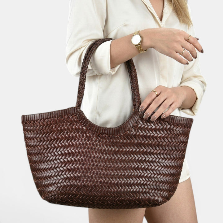 Detalle del bolso shopper de rafia trenzada y piel. Un accesorio femenino y elegante para el verano.