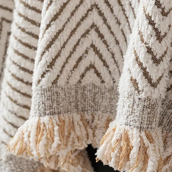 Textil hogar: funda de sofá drapeada con flecos, patrón espiga. Transforma tu sala de estar con elegancia.
