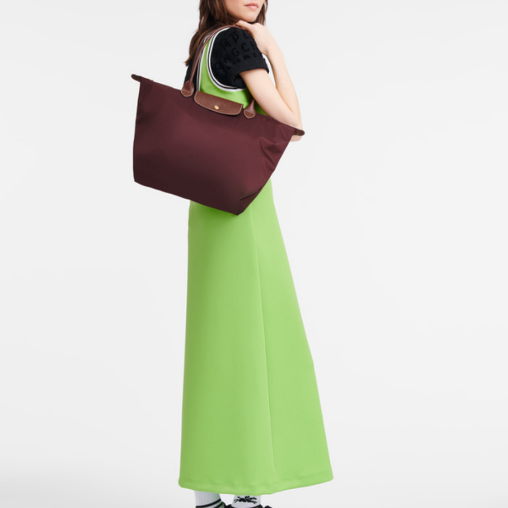 Acabado de piel en el bolso de mano de nylon, añadiendo un toque de lujo sutil para la mujer moderna.