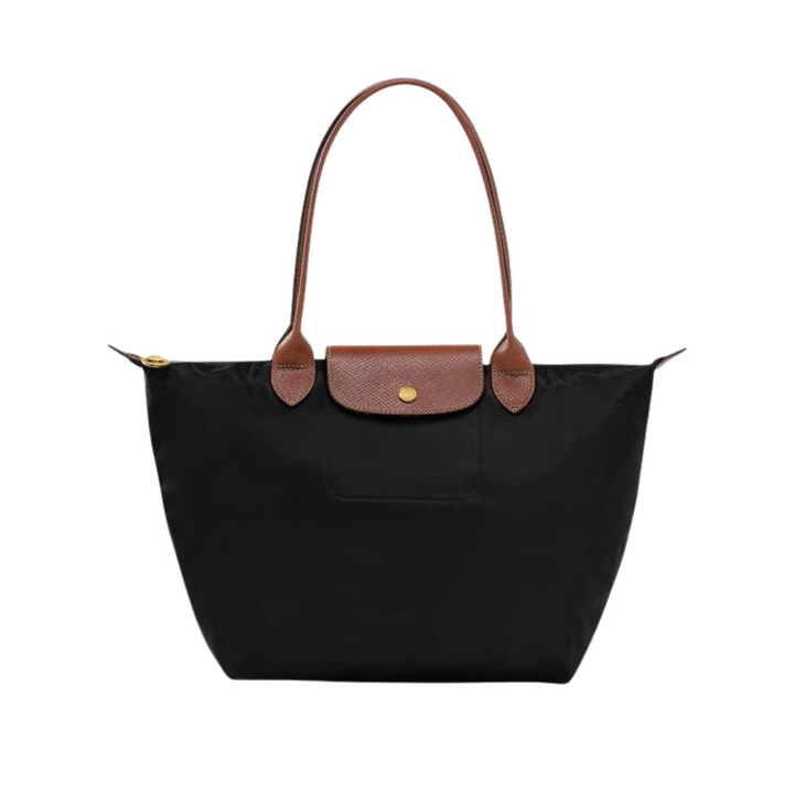 Mujer usando bolso de mano de nylon y piel, mostrando su comodidad, estilo y practicidad diaria.