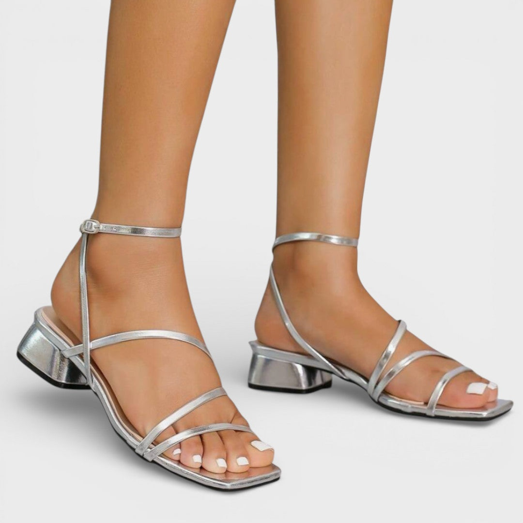 Detalle sandalias mujer tacón grueso. Tiras cruzadas elegantes. Calzado versátil para eventos de día o noche.