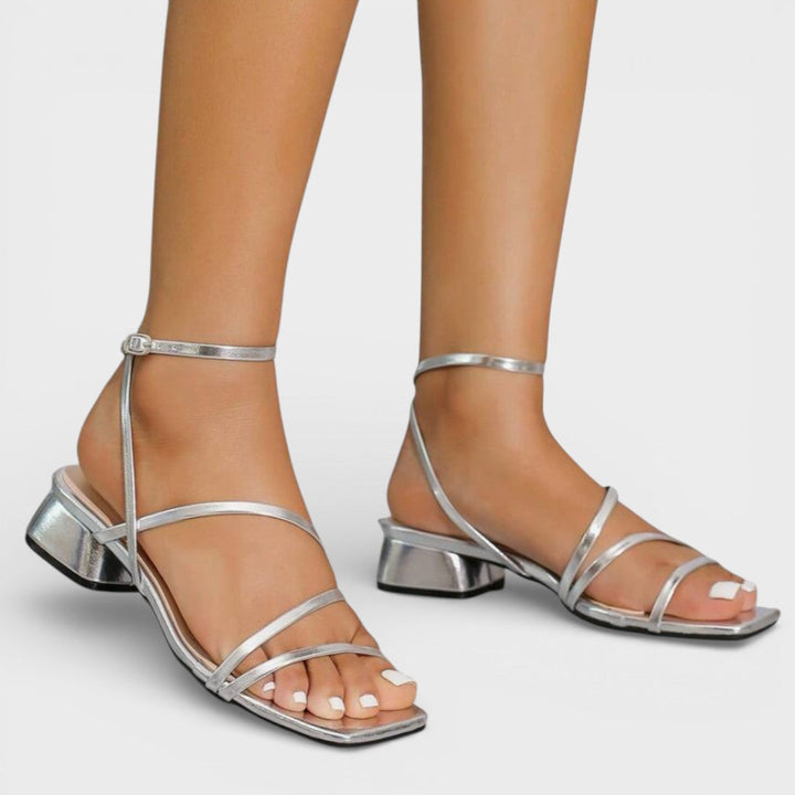 Detalle sandalias mujer tacón grueso. Tiras cruzadas elegantes. Calzado versátil para eventos de día o noche.